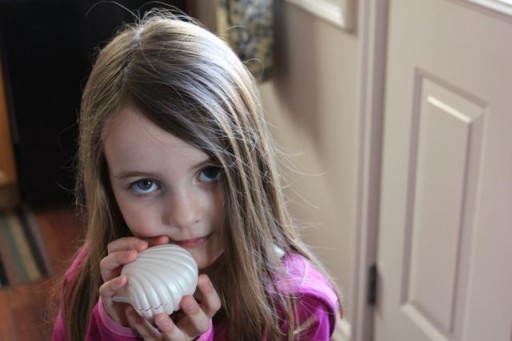 little girl holding a shell toy