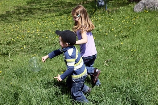 two kids enjoys playing the bubbles 