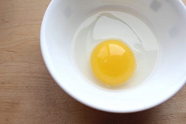Duck Egg Cracked into white Bowl