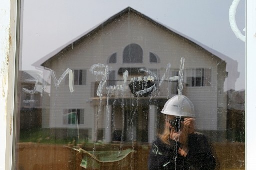 housefirstwalkthrough12 lady taking picture in front of window glass