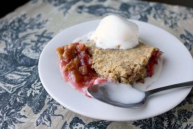 classic rhubarb and strawberry crisp in a white plate with a spoon