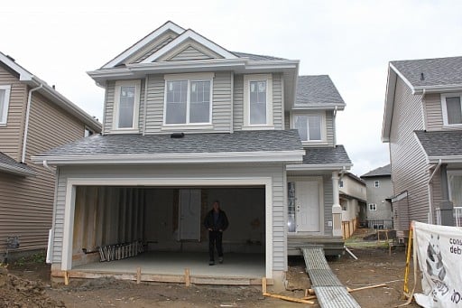 a man in front of a new house