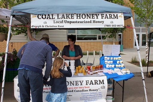 Dad and little daughter at the Coal Lake Honey Farm booth