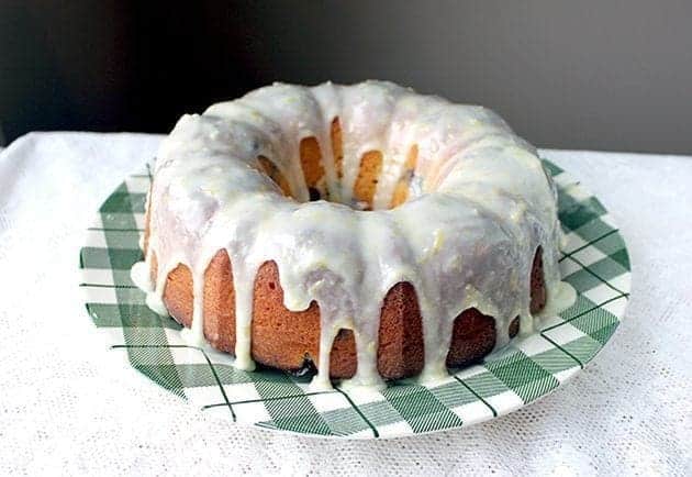 Close up of Greek Yogurt Blueberry Lemon Bundt with Lemon Icing Glaze placed on a green checkered plate