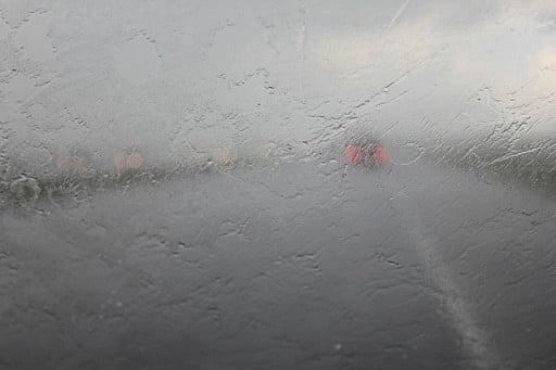 storm front mirror of car full of rain water