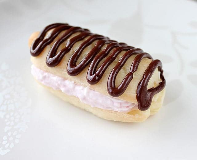 Eclairs - classic French choux pastry cream filled delights with crunchy chocolate drizzles on top