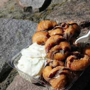 Chocolate sauce, peanut butter and whipped cream over mini donuts