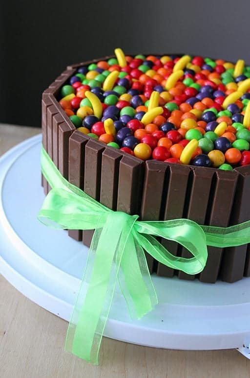 close up of Willy Wonka colorful Cake with KitKat bars and green ribbon