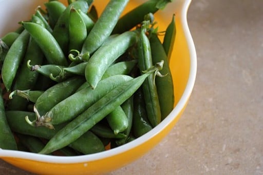 raw peas in a yellow bowl