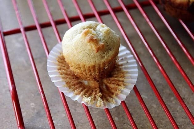 a piece of mini muffin with paper liner removed in a red cooling rack