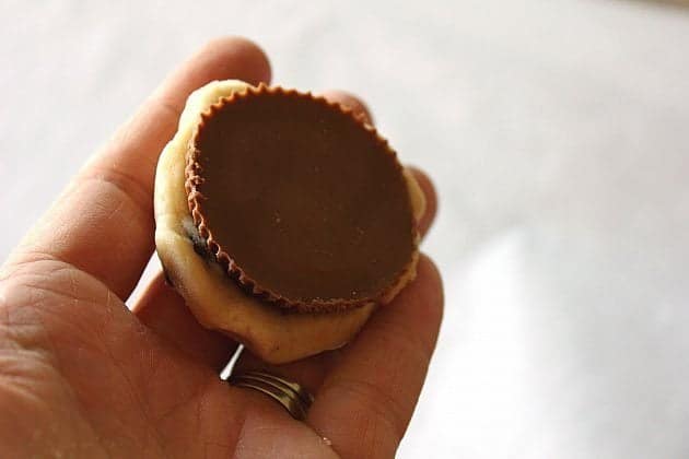 Flattened scoop of a cookie dough chocolate chip cookie with peanut butter cup on top