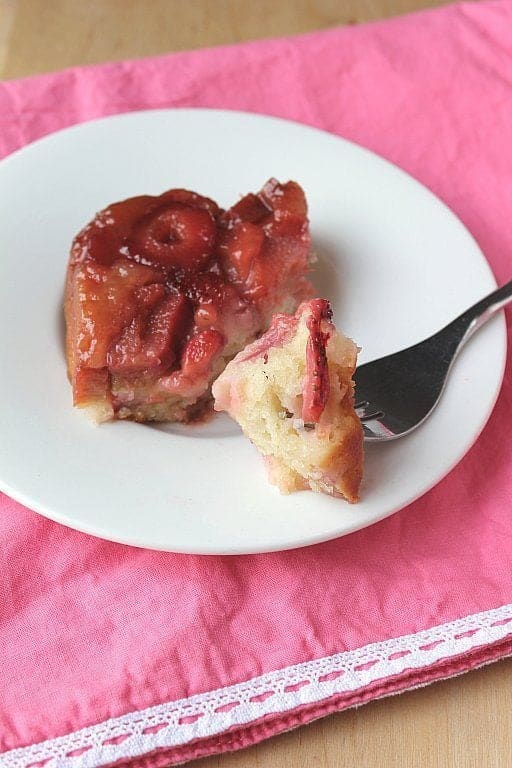 A slice of Strawberry Rhubarb Upside Down Cake in a white dessert plate