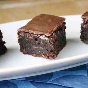 close up of brownies with Creme de Menthe chips on top placed on white plate