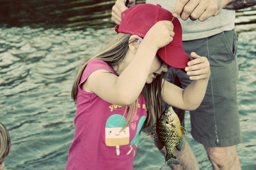 little girl whispering to the fish in the string