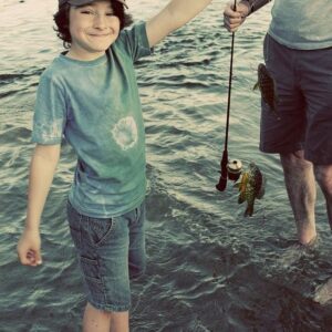 kid holding his small catch fish
