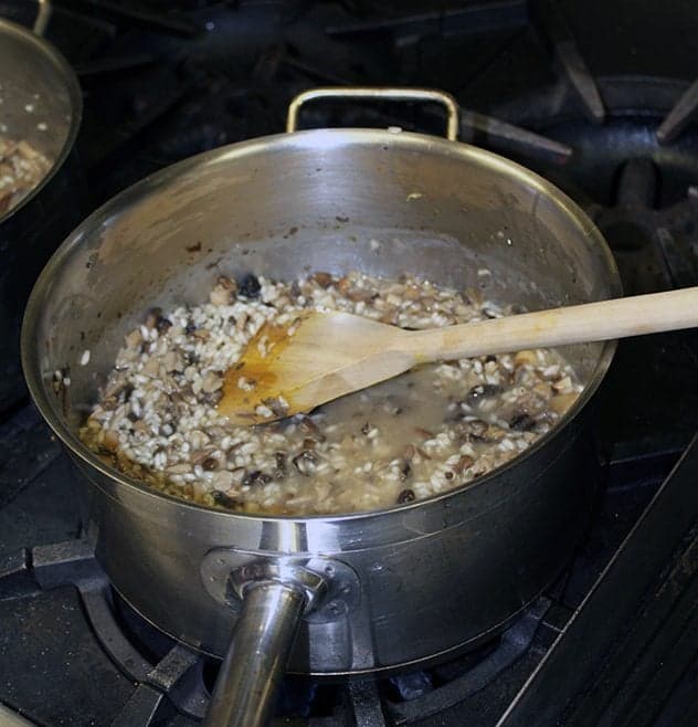 stirring all the ingredients in a large pot using wooden cooking spoon