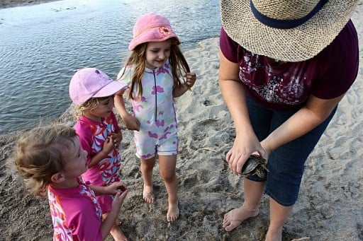 Mom holding the turtle while kids looking at her