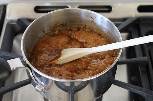 cooking in sugar syrup for pancakes in casserole pot using wooden spoon