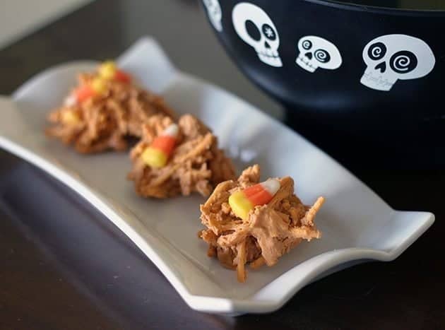 Candy Corn Haystacks on a small white rectangular plate, a spooky black bowl on the side