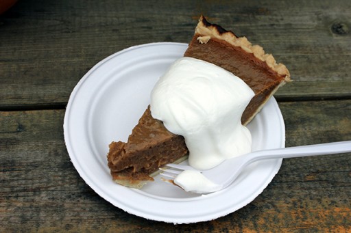 a slice of prairie gardens pumpkin pie in a white plate topped with whipped cream