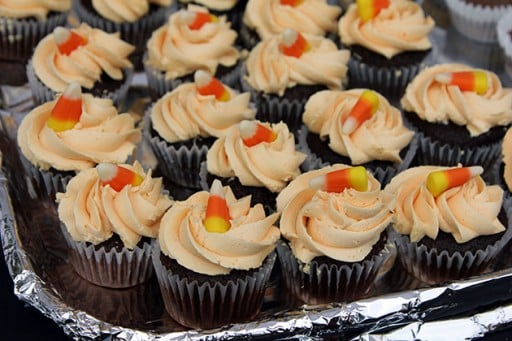 gluten free chocolate cupcakes topped with icing and a piece of candy