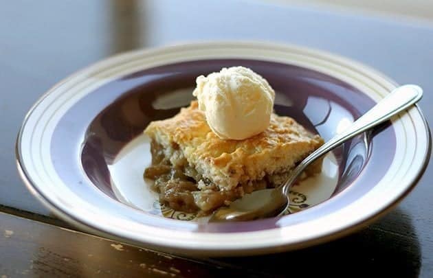 a slice of PEAR COBBLER vanilla ice cream on top on a blue designed plate