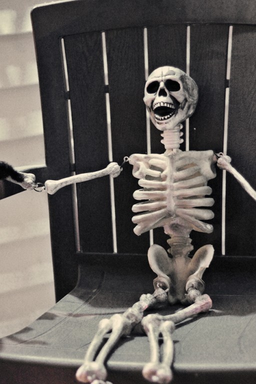sitting human skeleton on black chair