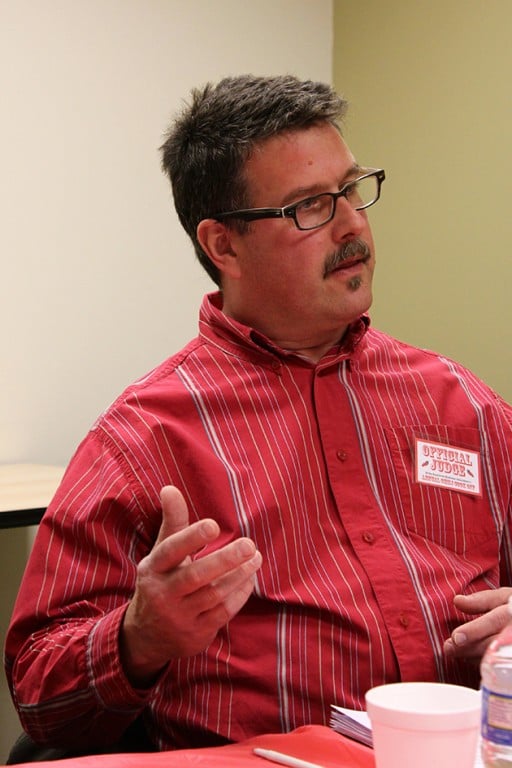 man with eye glasses on, wearing red dress shirt