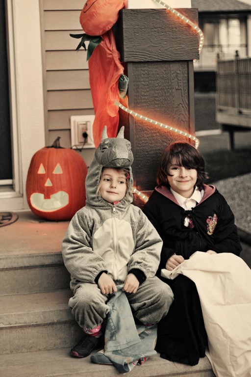  kids sitting in the stairs wearing halloween costume