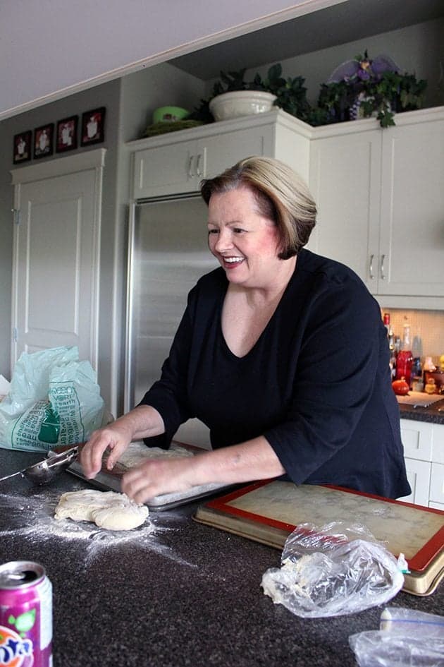 a woman in the kitchen preparing a dough