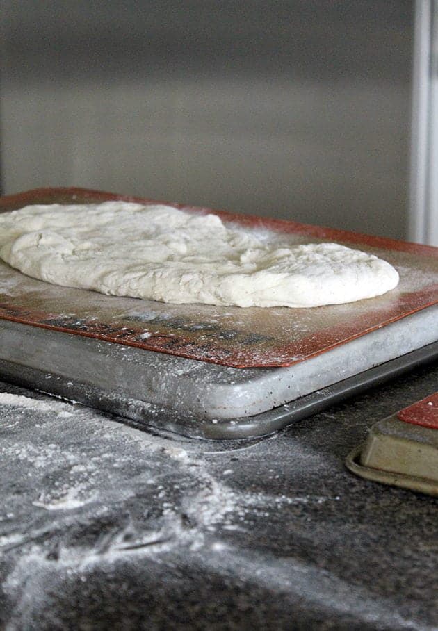 big pizza dough in pizza tin
