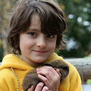 close up of a little boy wearing yellow jacket