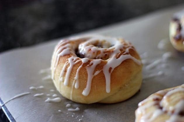 cinnamon bun drizzled with icing sugar