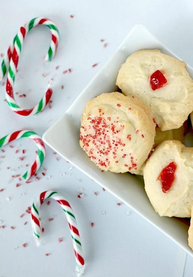 close up Old Fashioned Whipped Shortbread in a white plate, some candy cane on table