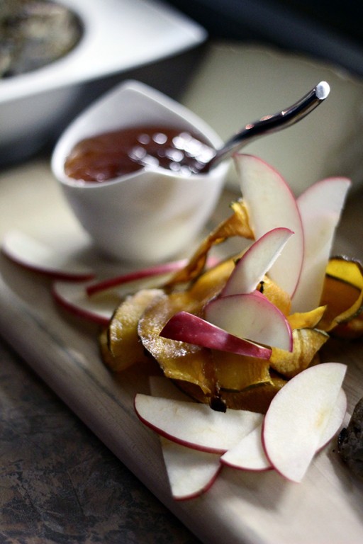 dried and fresh slices of apples with a dipping sauce on background