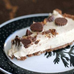 Slice of Peanut Butter Cup Pie with caramel drizzled over the top in a black and white vintage plate