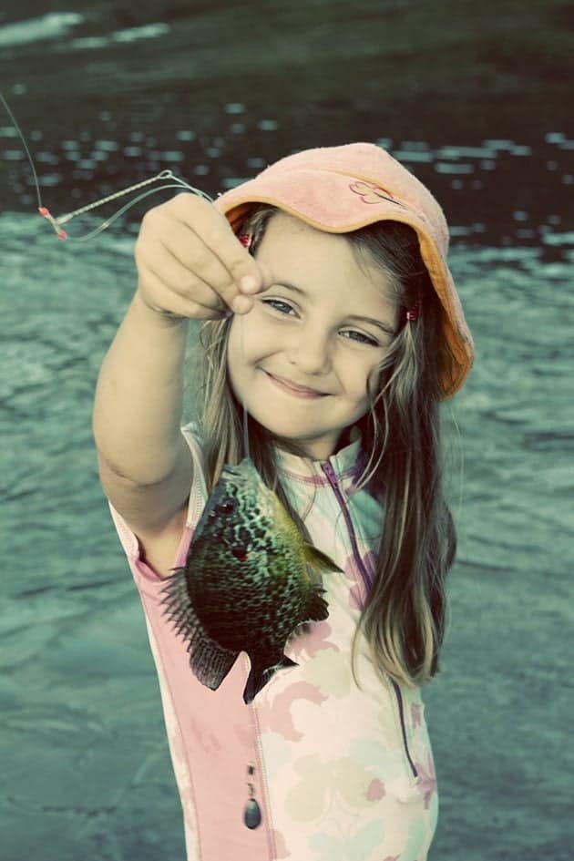 cute little girl holding a string with fish in it