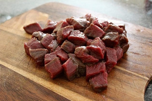 cubed elk meat in wooden board