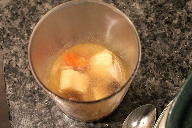 some cups of stew added to potatoes in a glass