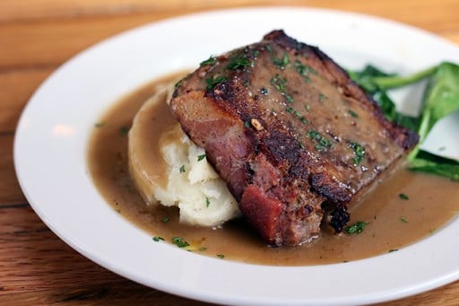 Pleasant Creek ranch beef, lamb & pork with creamy decadent mashed potatoes and a side of sautéed spinach in a white plate