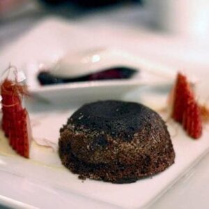 lava cake with spicy pepper threads and berries in a white plate