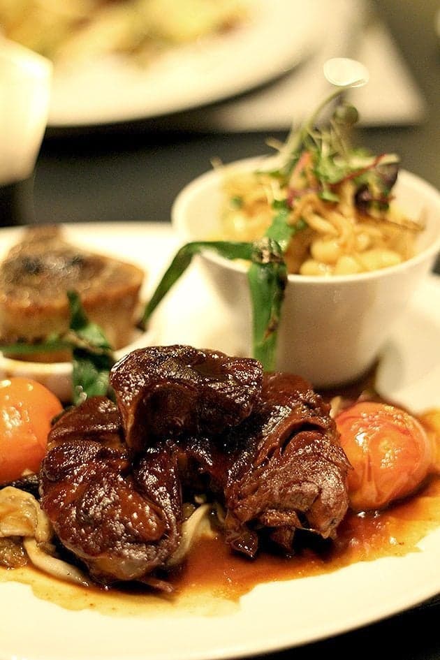 braised veal leg, macaroni and cheese, grilled green onions, Campania tomatoes, and wild mushrooms