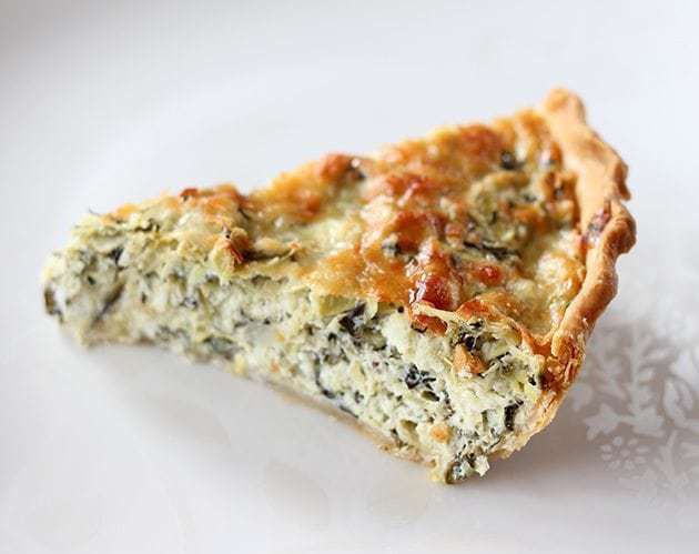 A Slice of Artichoke & Spinach Pie in white Background