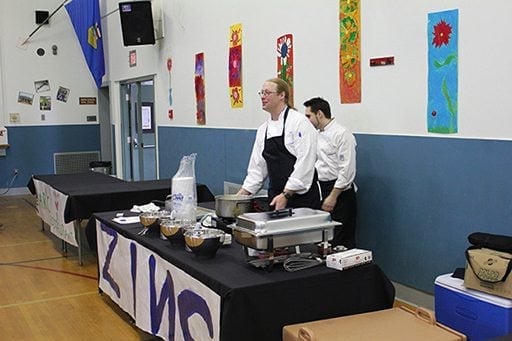 the Zinc table with two male chefs wearing black kitchen apron