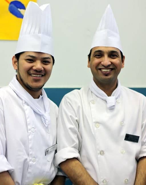 two male chefs with their full white uniforms