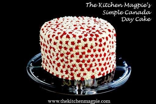 Canada Day Cake with red and white star icing on a clear cake stand