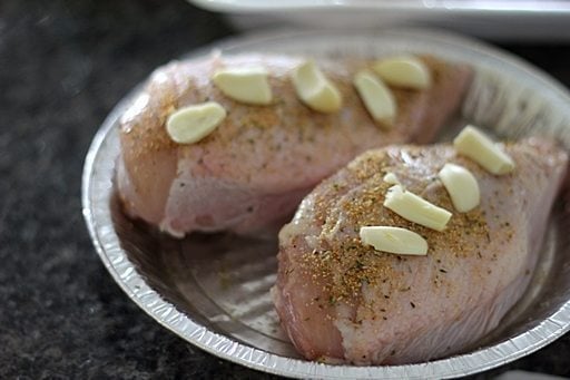 two pieces chicken breasts sprinkled with Mrs Dash and topped with sliced garlic
