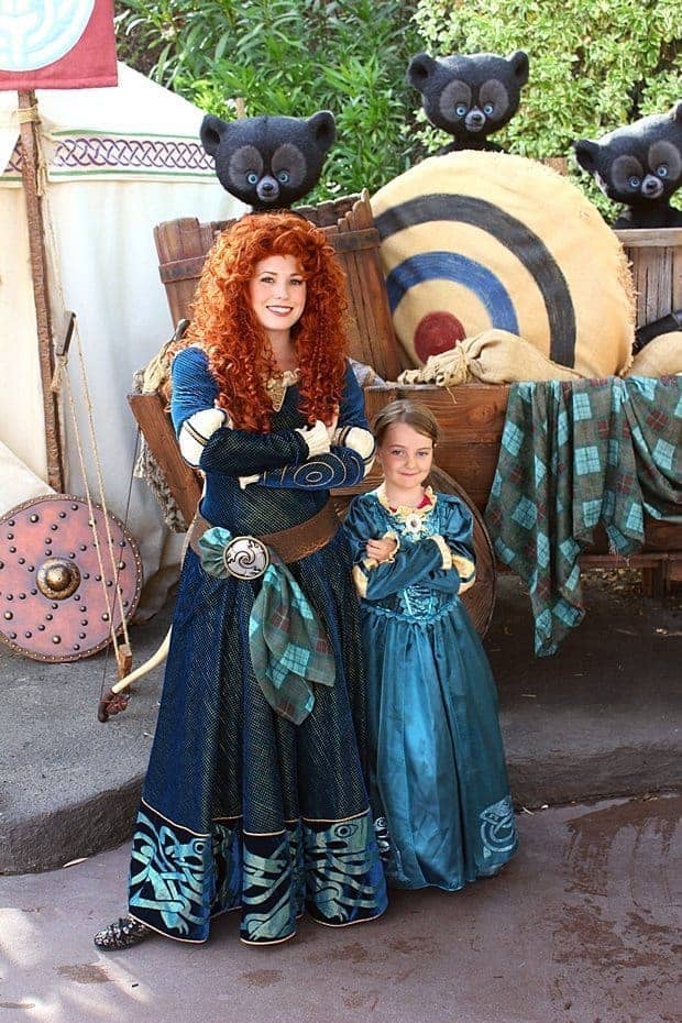young girl wearing princess Merida dress and the Disneyland character princess Merida