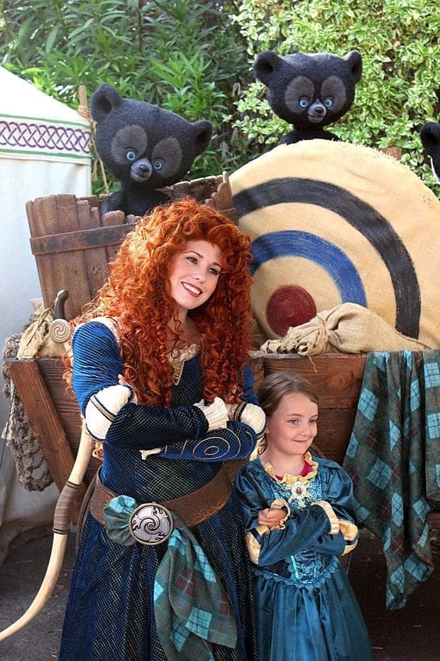 close up of Disneyland's Princess Merida and a kid wearing same princess' dress