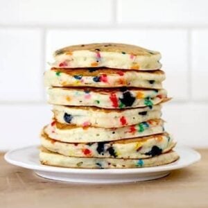 stack of bright and colorful Funfetti Pancakes in a white plate